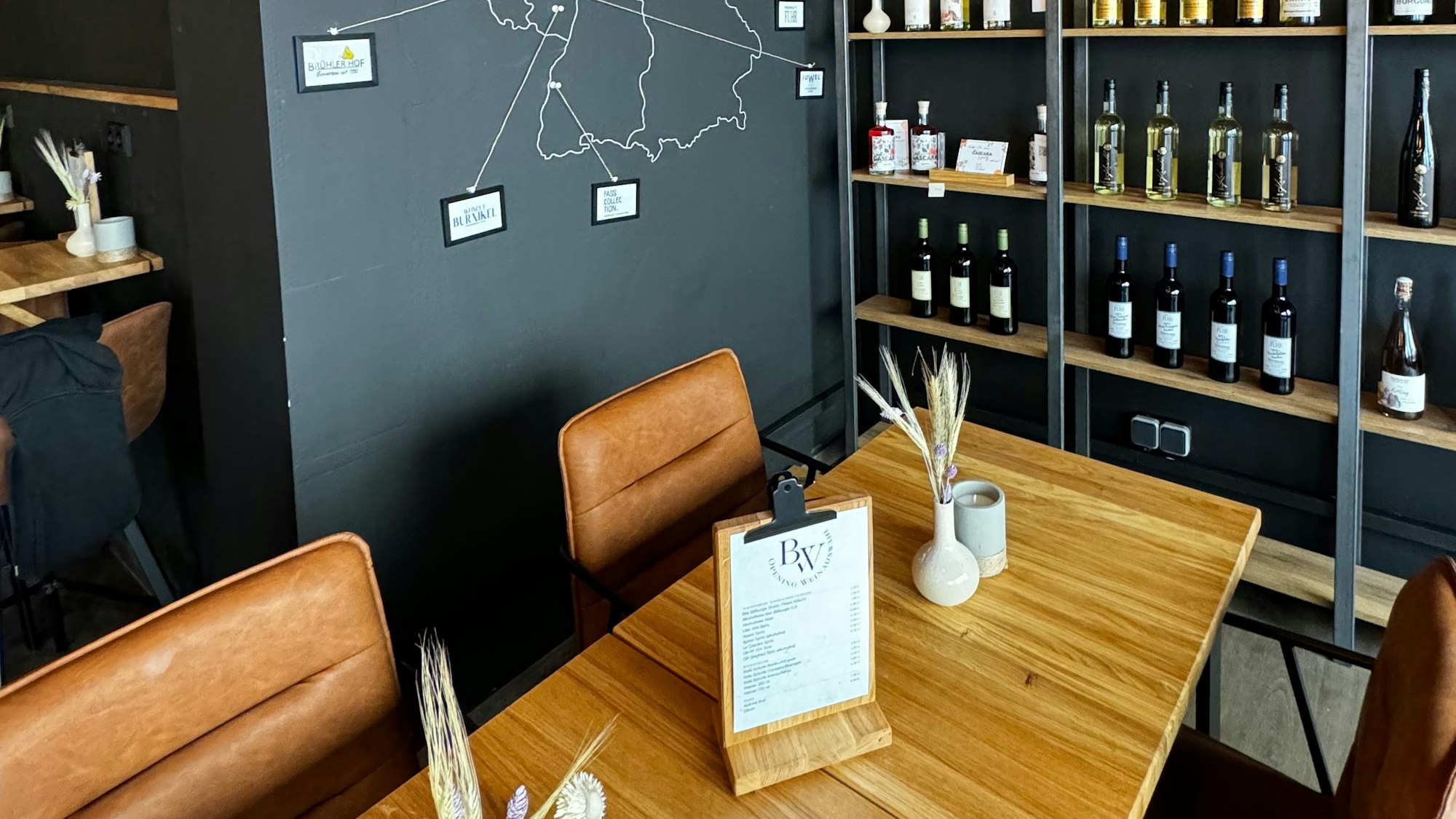 Schick und edel wirkt das Ambiente im Weinkonzept in Beuel: bequeme, mit braunem Kunstleder bezogene Stühle und die Regale sind mit Weiflaschen gefüllt.