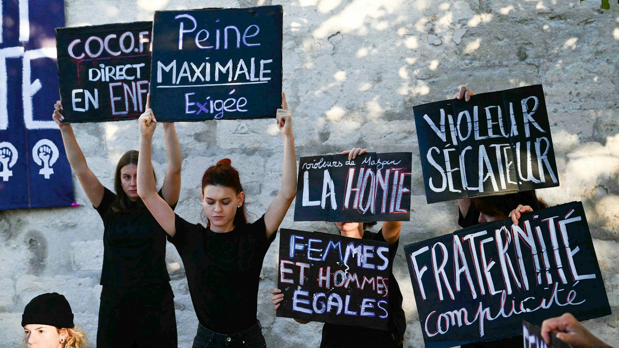 Demonstranten halten Plakate während eines Protestes vor dem Gerichtsgebäude