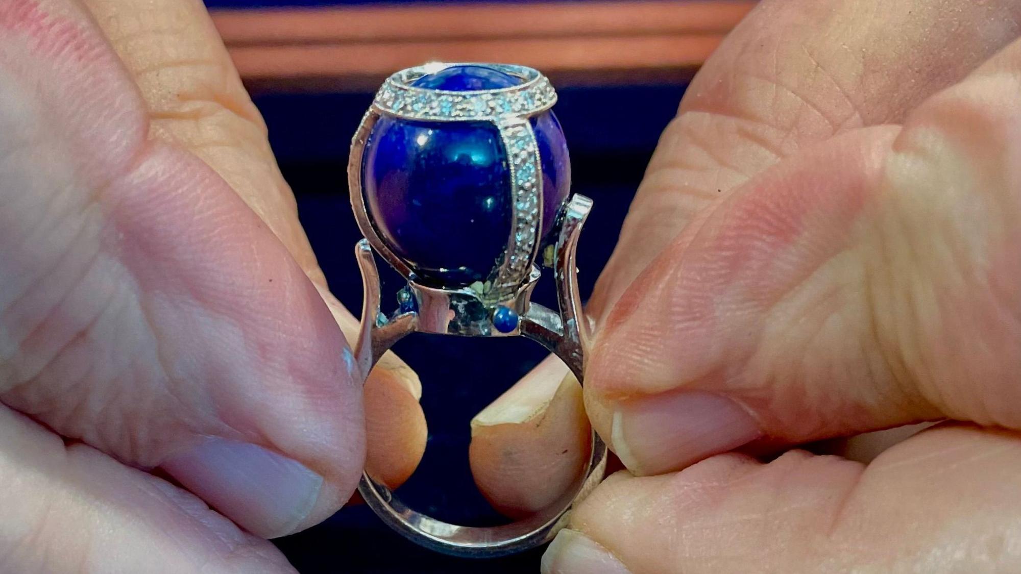Ring mit Kugelstein, der mit Diamanten besetzt ist.