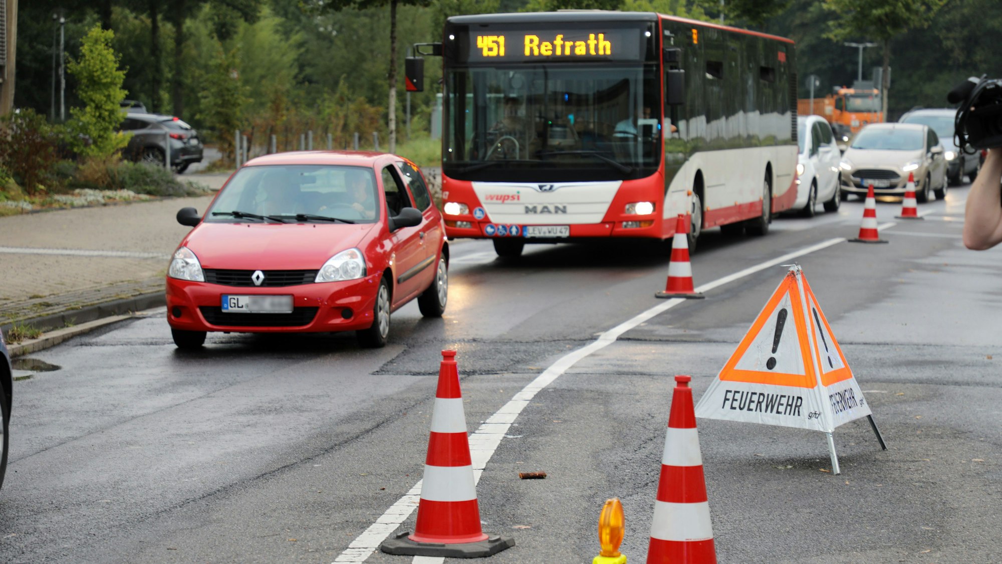 Ein Aufsteller-Schild mit der Aufschrift „Feuerwehr“ steht auf der Straße „An der Gohrsmühle“ dahinter sind Autos und ein Bus zu sehen.