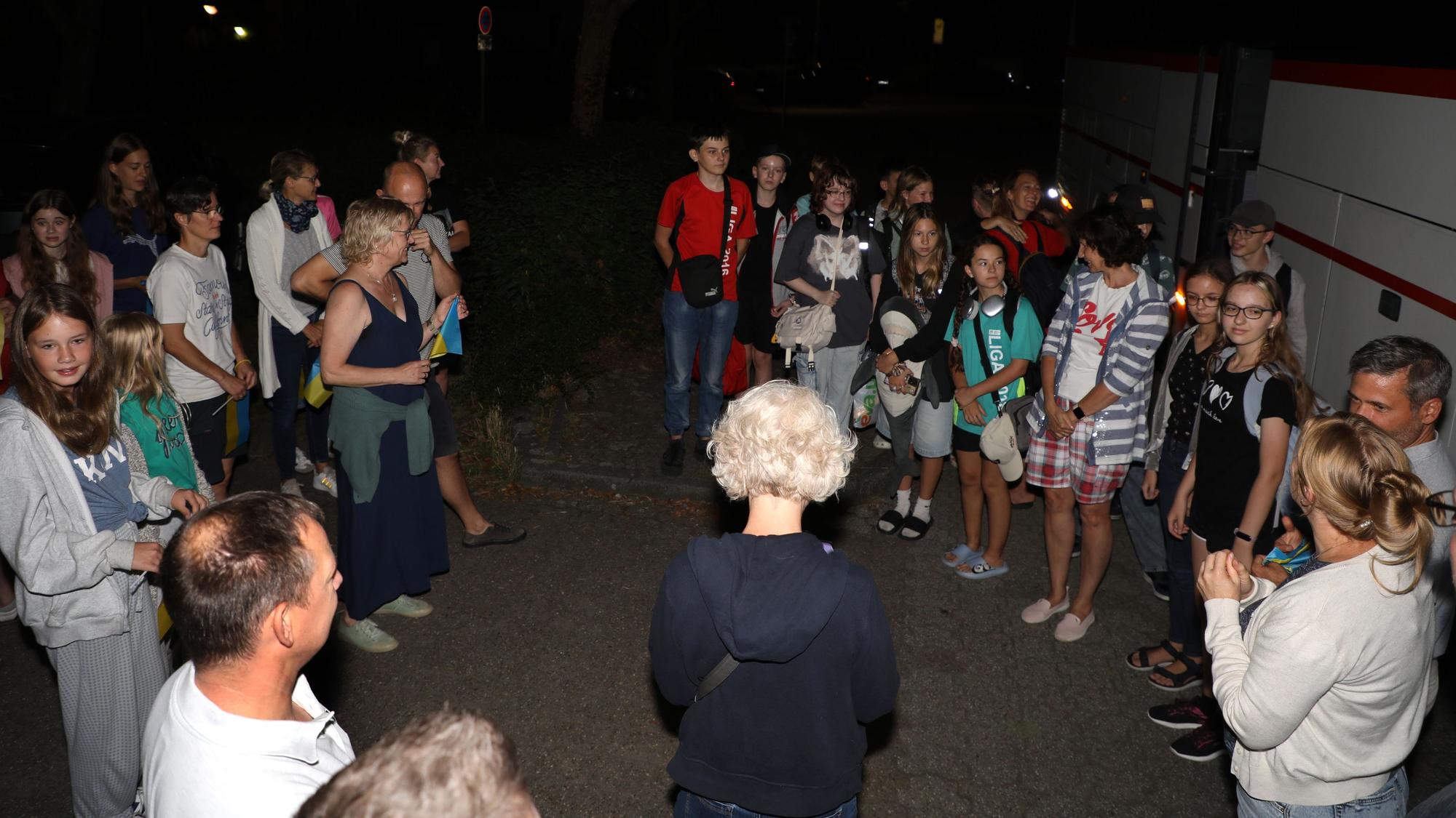Zwei Gruppen von Kindern und Erwachsenen stehen sich gegenüber.
