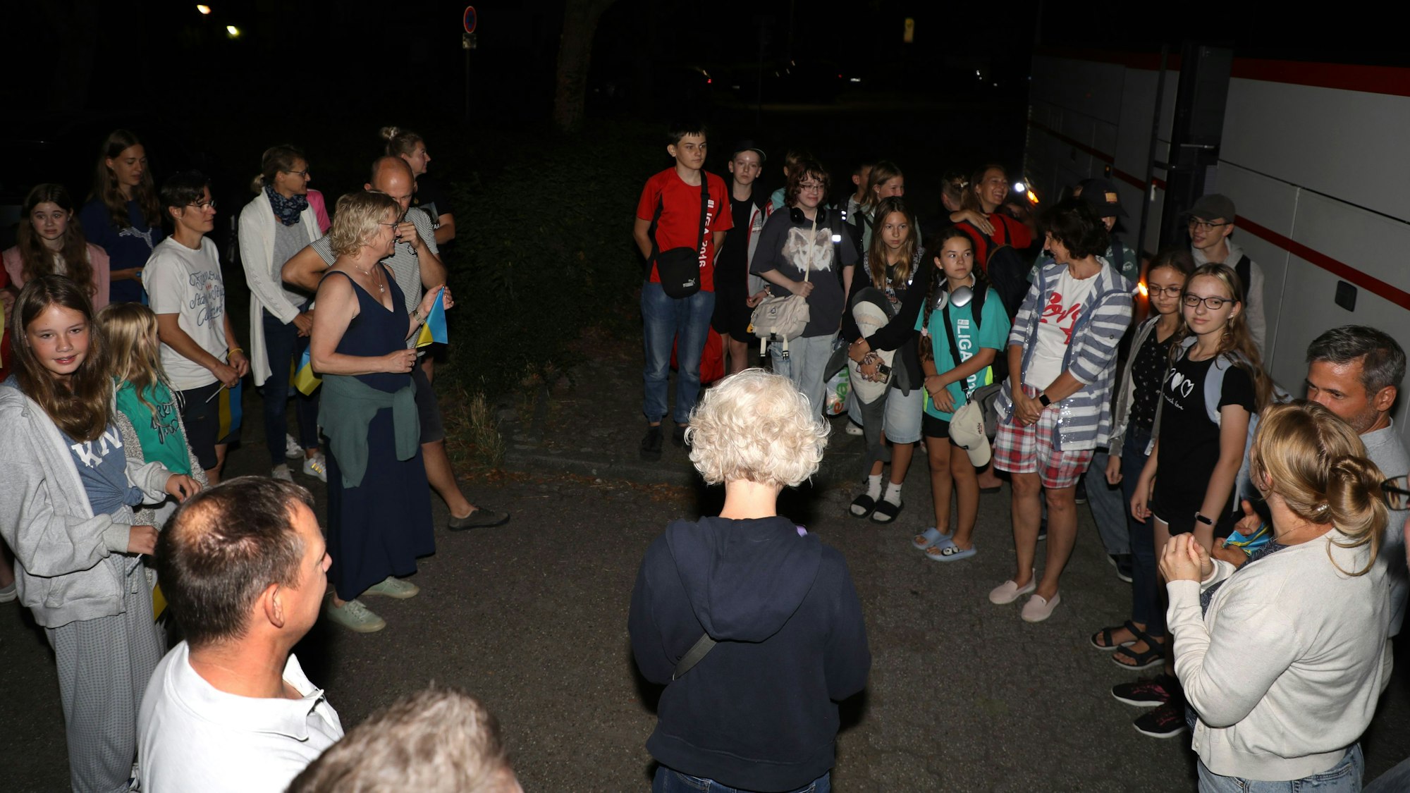 Zwei Gruppen von Kindern und Erwachsenen stehen sich gegenüber.