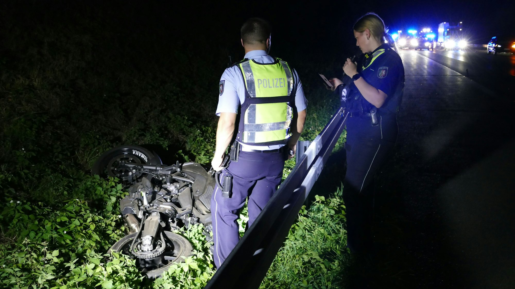 Polizeibeamte untersuchen das verunglückte Motorrad.