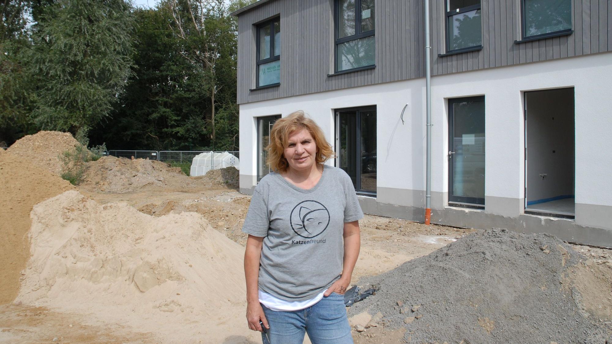 Eine Frau steht vor einem Gebäude.