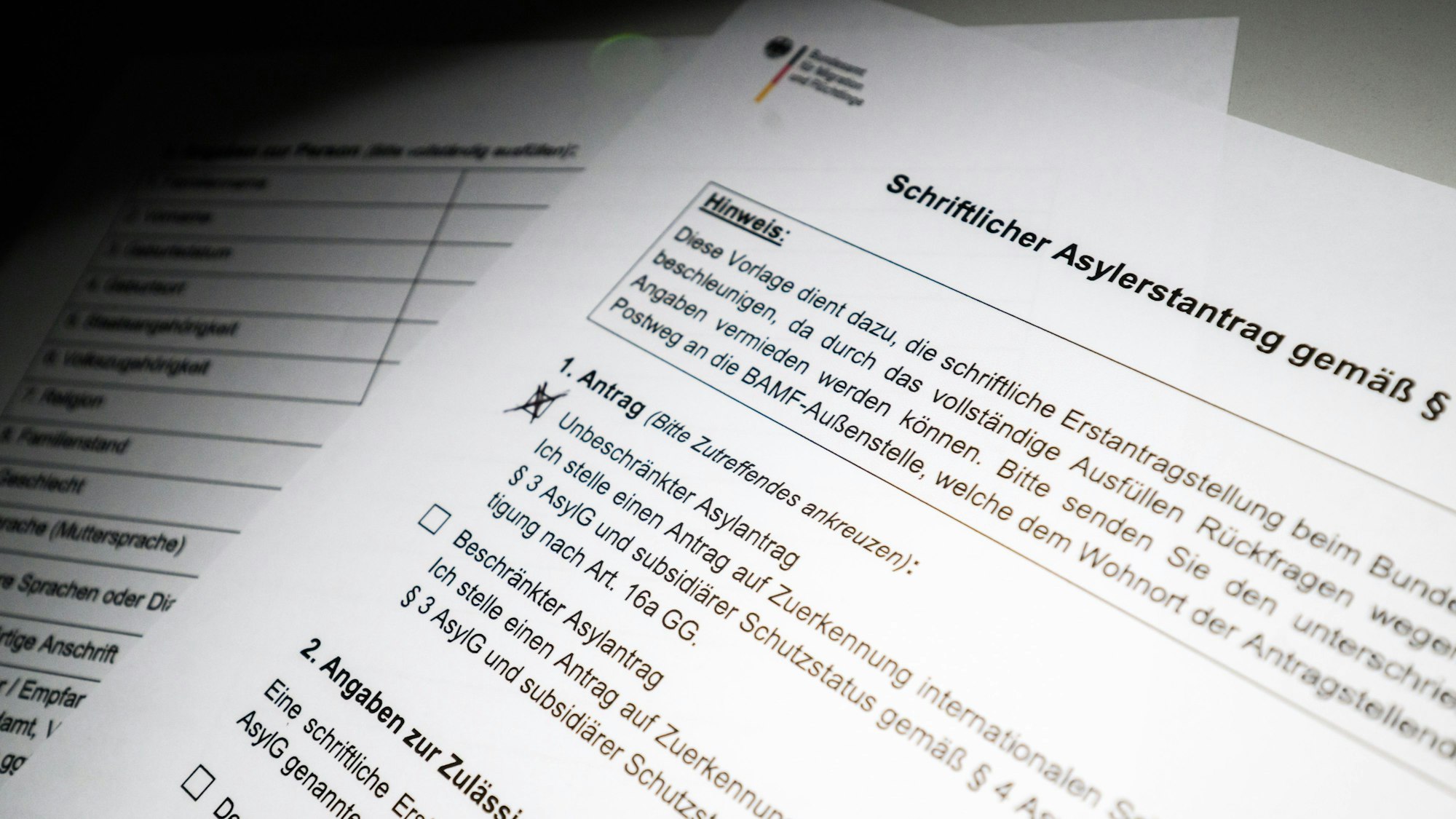 Ein schriftlicher Asylerstantrag des Bundesamts für Migration und Flüchtlinge (BAMF) liegt auf einem Tisch (gestellte Szene)