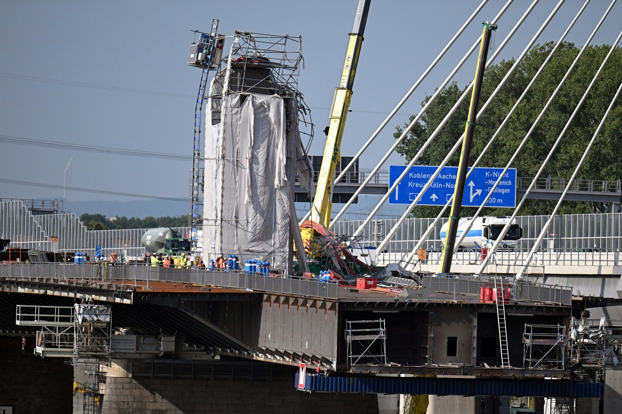 Leverkusen: Verbogene Gerüstteile hängen an dem Pfeiler der Leverkusener Brücke.