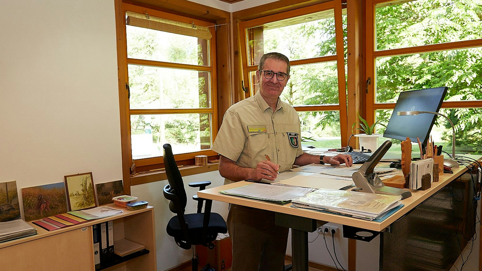 Christoph Böltz steht an seinem höhenverstellbaren Schreibtisch.