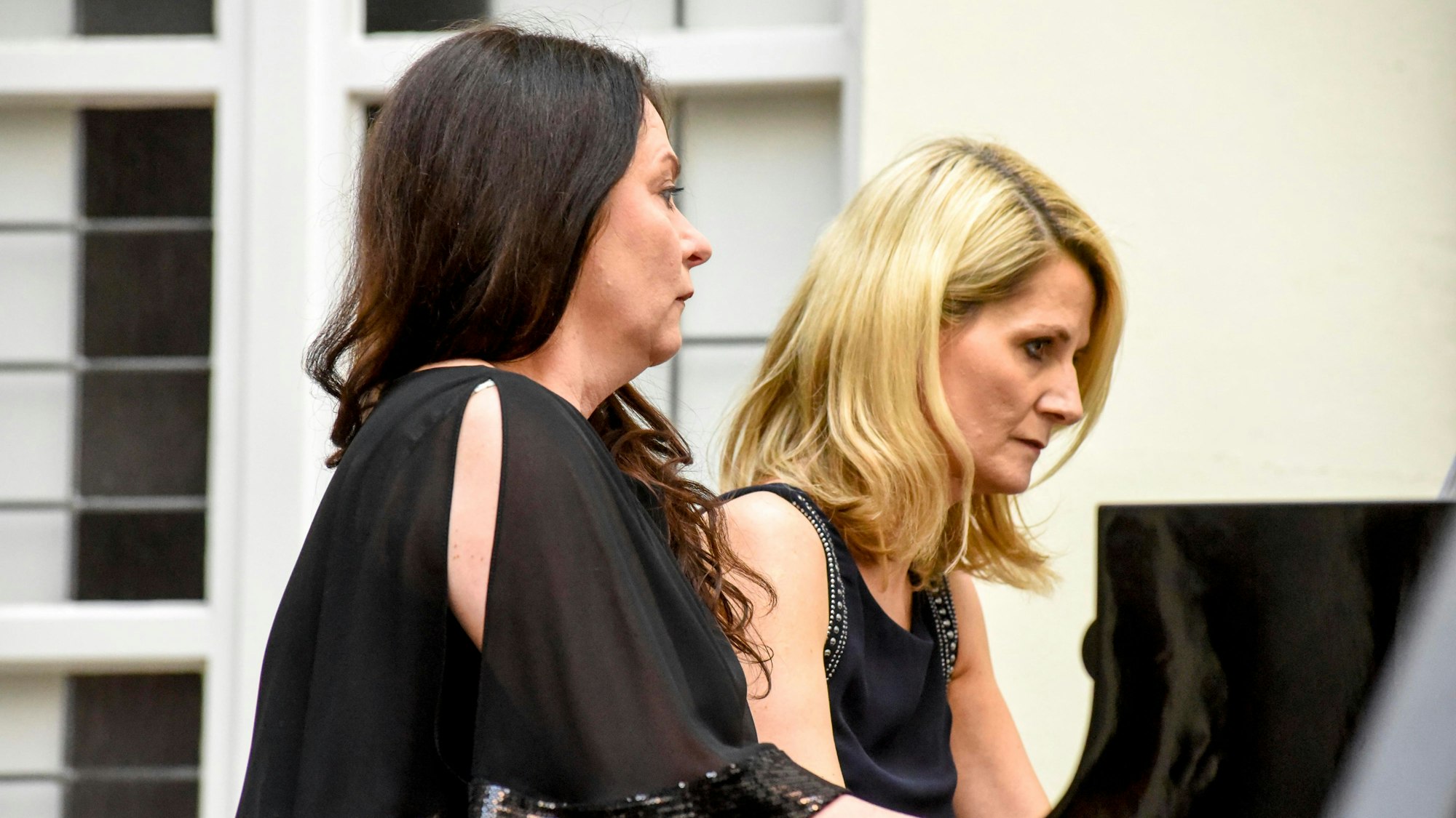 Zwei Frauen spielen gemeinsam auf einem Flügel. Sie sind in Schwarz gekleidet.