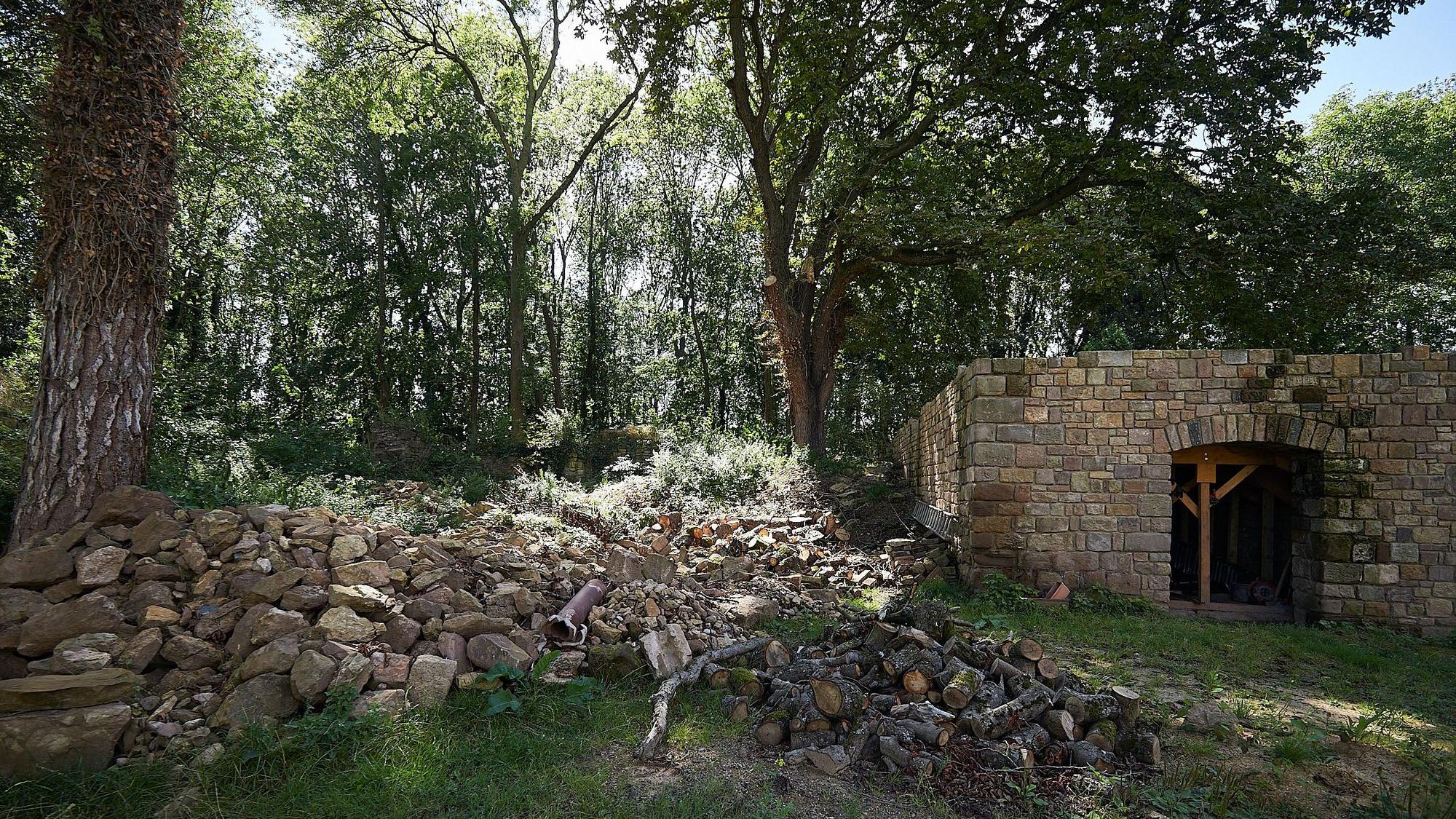 Ein Blick in den zum Teil noch desolaten Innenhof, im Hintergrund ist Wald zu erkennen.