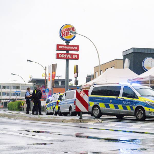 Einsatzkräfte sichern das Areal nahe des Schnellrestaurants in Bonn, nachdem ein Mann zwei ihm bekannte Menschen auf der Straße mit einem Messer angegriffen und verletzt hat.