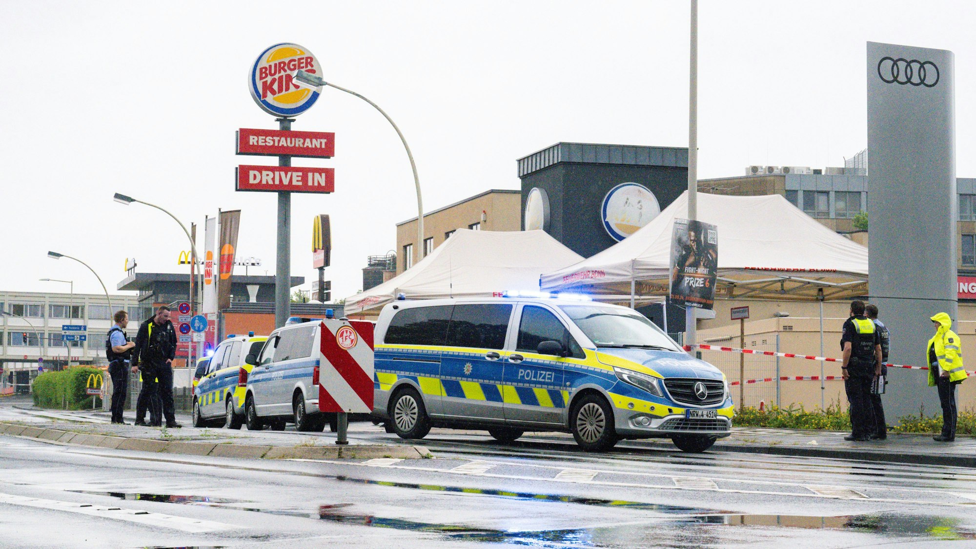 Einsatzkräfte sichern das Areal nahe des Schnellrestaurants in Bonn, nachdem ein Mann zwei ihm bekannte Menschen auf der Straße mit einem Messer angegriffen und verletzt hat.