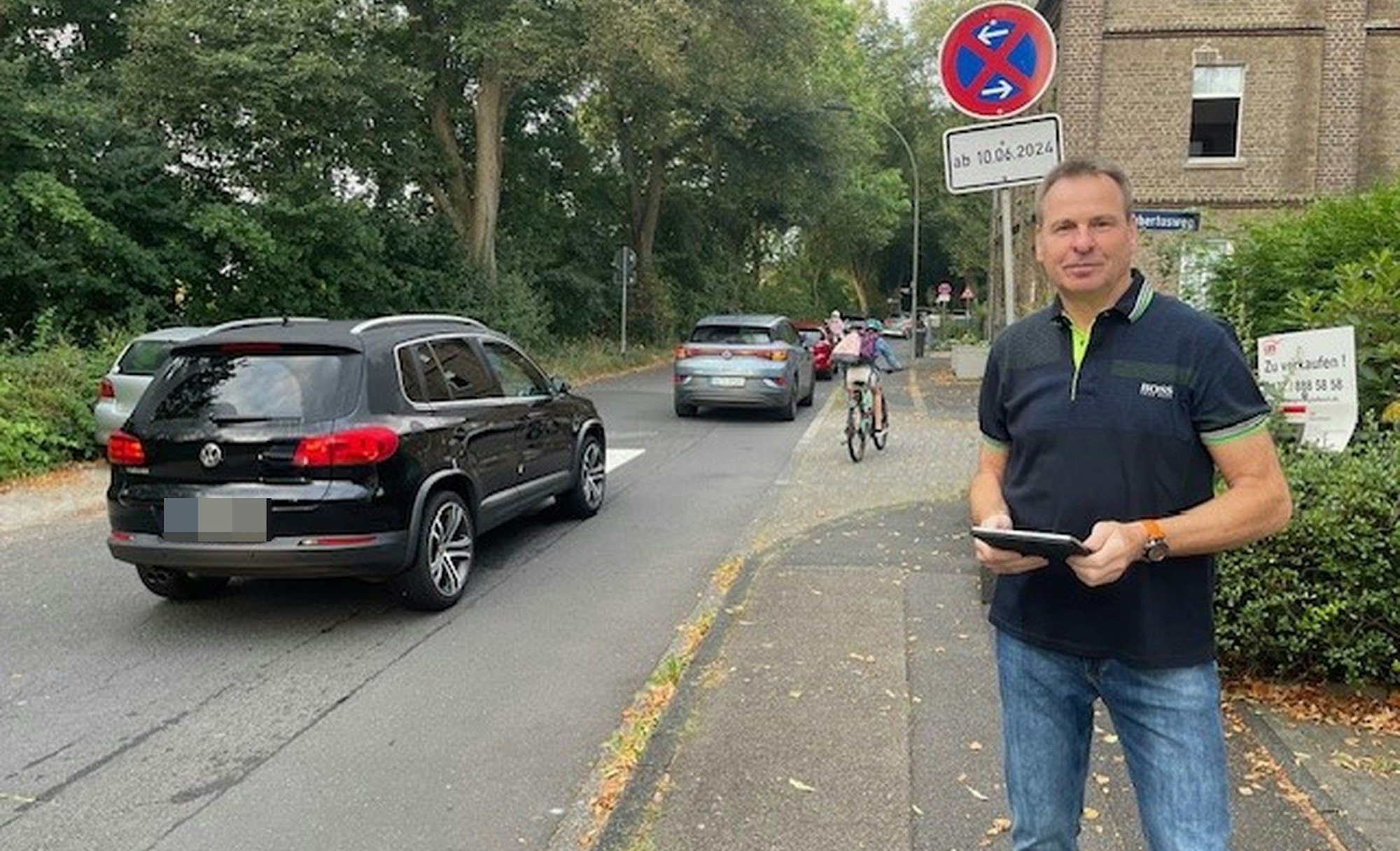 Ein Mann mit einem Tablet steht an einer Straße