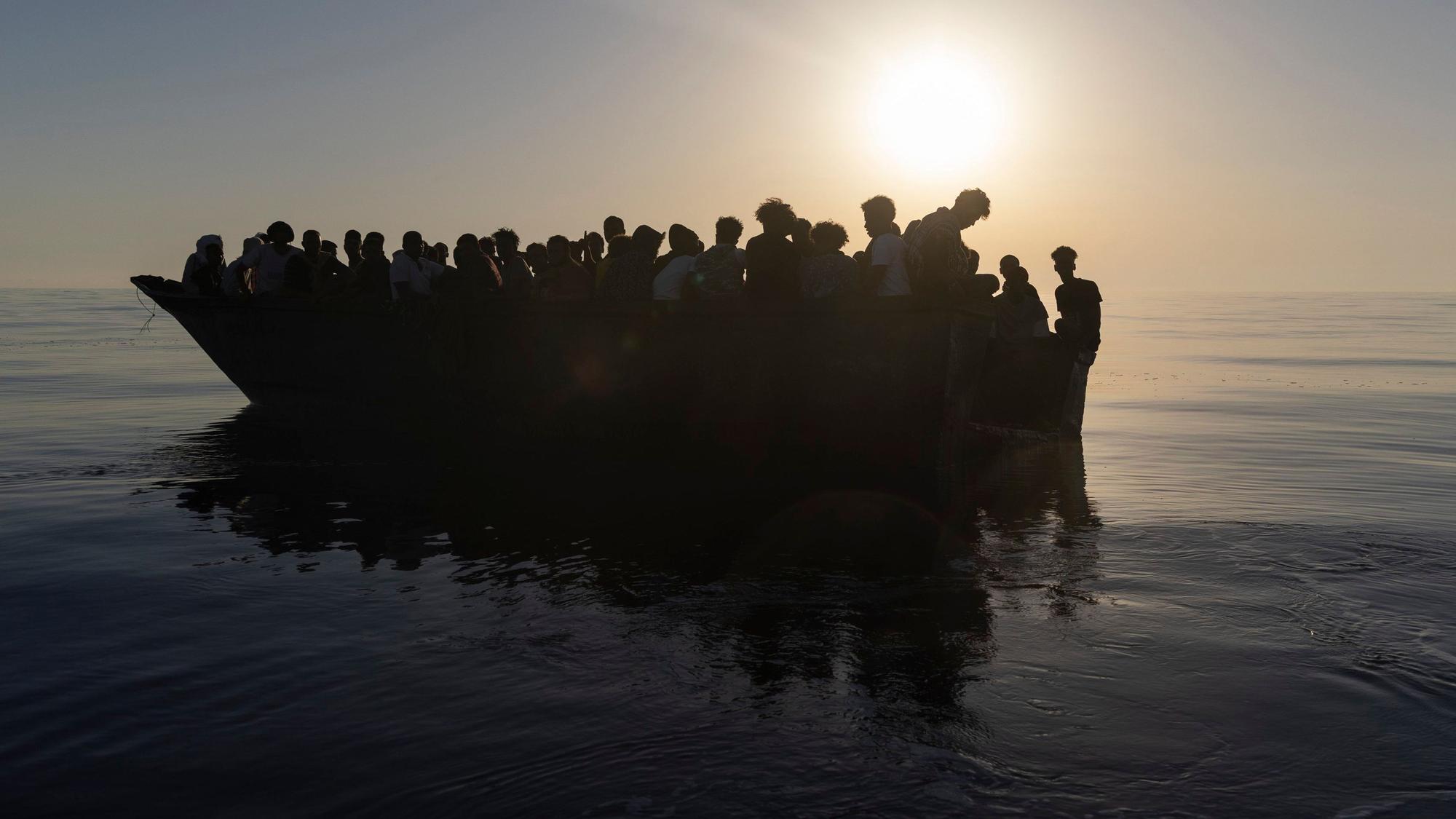 Migranten sitzen in einem Holzboot, während sie von Freiwilligen des Rettungsschiffs Ocean Viking gerettet werden. (Archivbild)