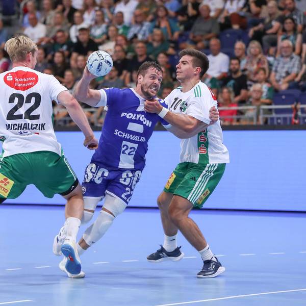 Handballer Kentin Mahé setzt sich im Angriffsspiel zwischen zwei gegnerische Spieler aus Hannover durch.