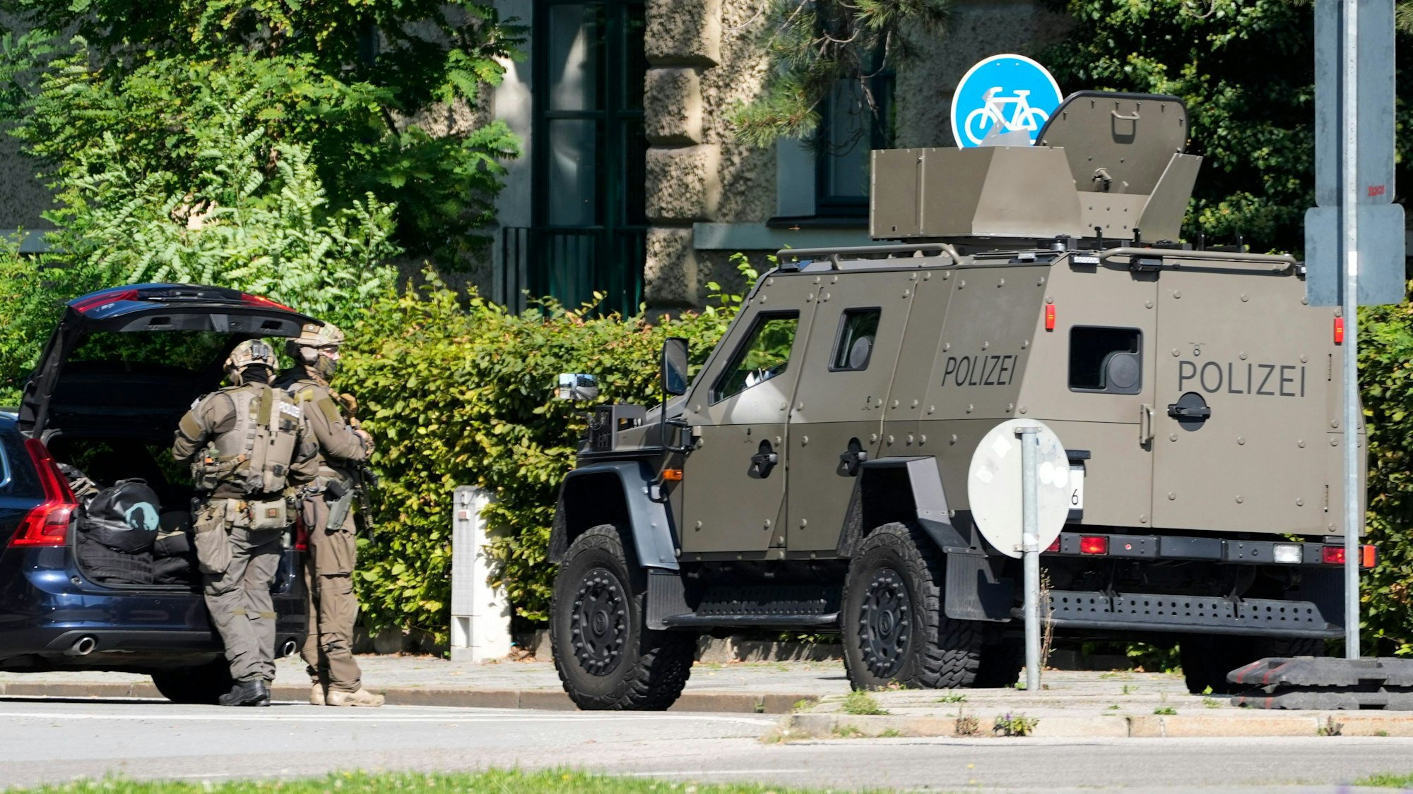 Polizisten in Spezialausrüstung und mit einem Spezialfahrzeug sind in München im Einsatz.