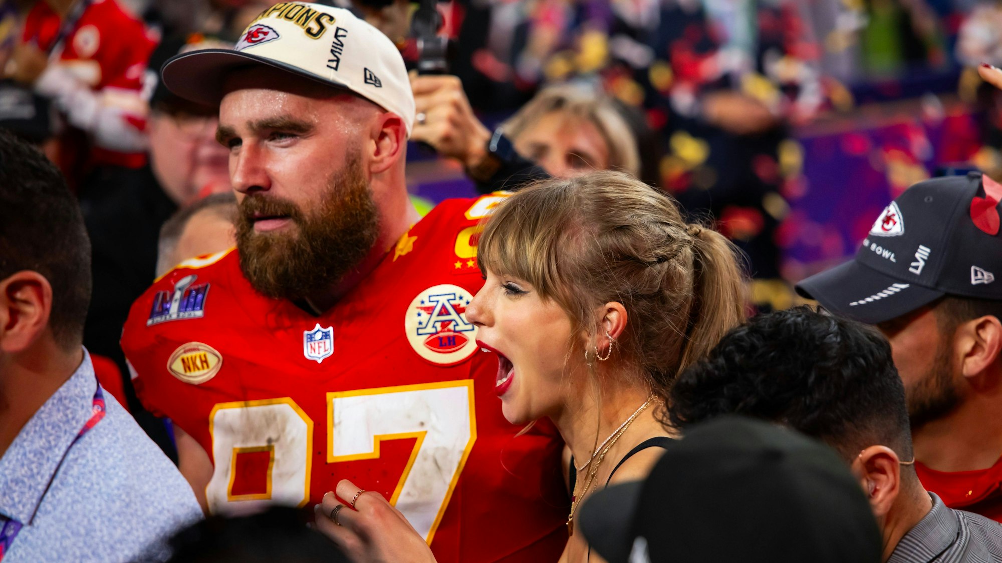 Taylor Swift und Travis Kelce feiern in der Menge.