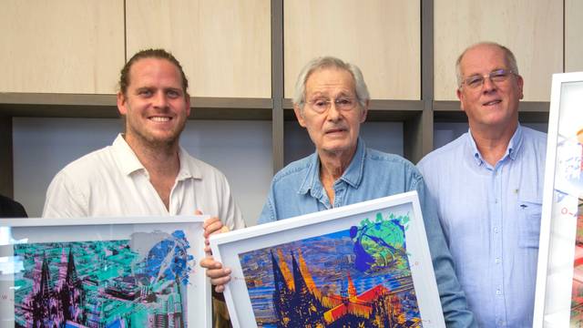 Grafiker Hans-Jürgen Kuhl (M.) präsentiert gemeinsam mit Lukas Boecker (l.) und Robert Boecker die limitierte Domgrafik, die der Zentral-Dombau-Verein zu Gunsten des Erhalts der Kathedrale vertreibt.