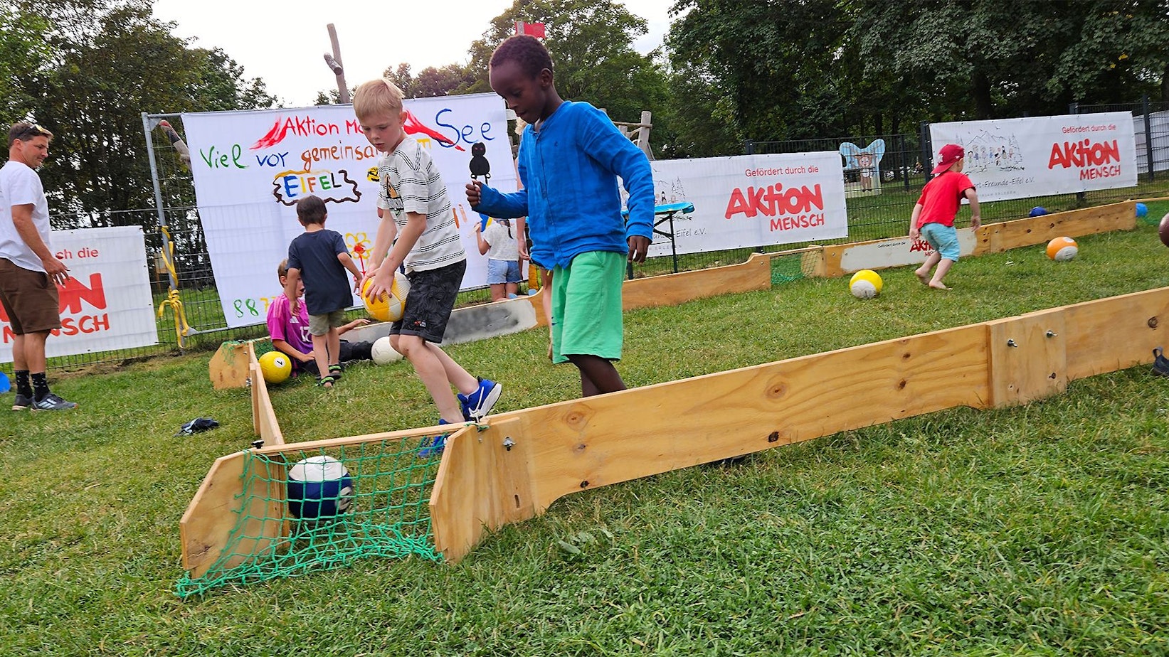 Zahlreiche Kinder spielen Fußball.