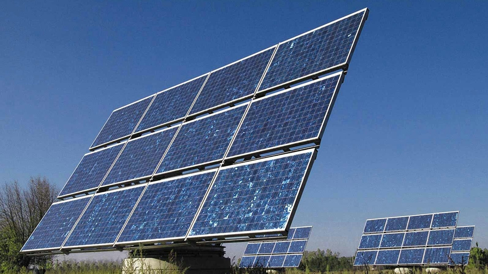 Elemente einer Photovoltaik-Anlage stehen auf einer Wiese.