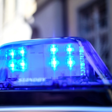 Ein Polizeiauto mit blinkendem Blaulicht steht vor einem Gebäude. (Archivbild)