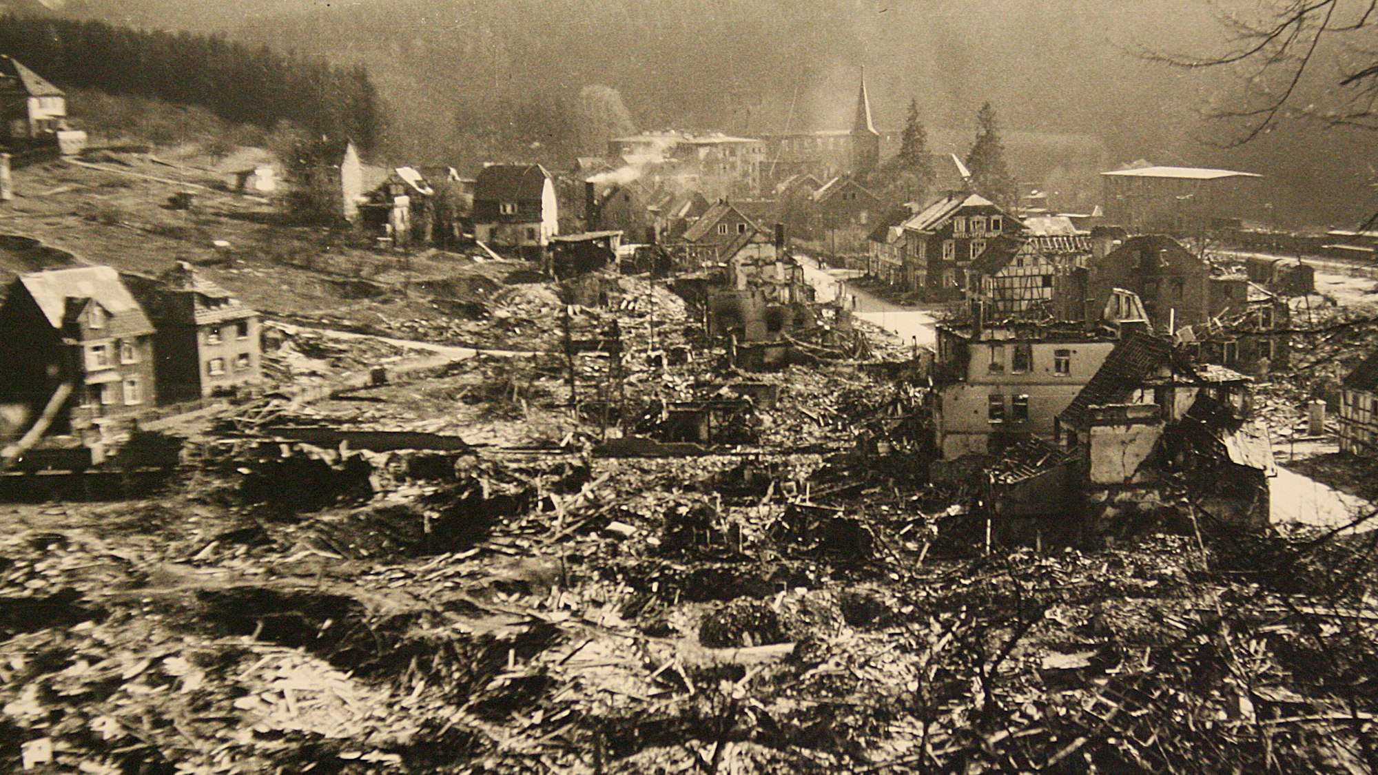 Blick auf den zerstörten Ortskern von Engelskirchen im März 1945. Rauch steigt noch aus einigen Ruinen auf.