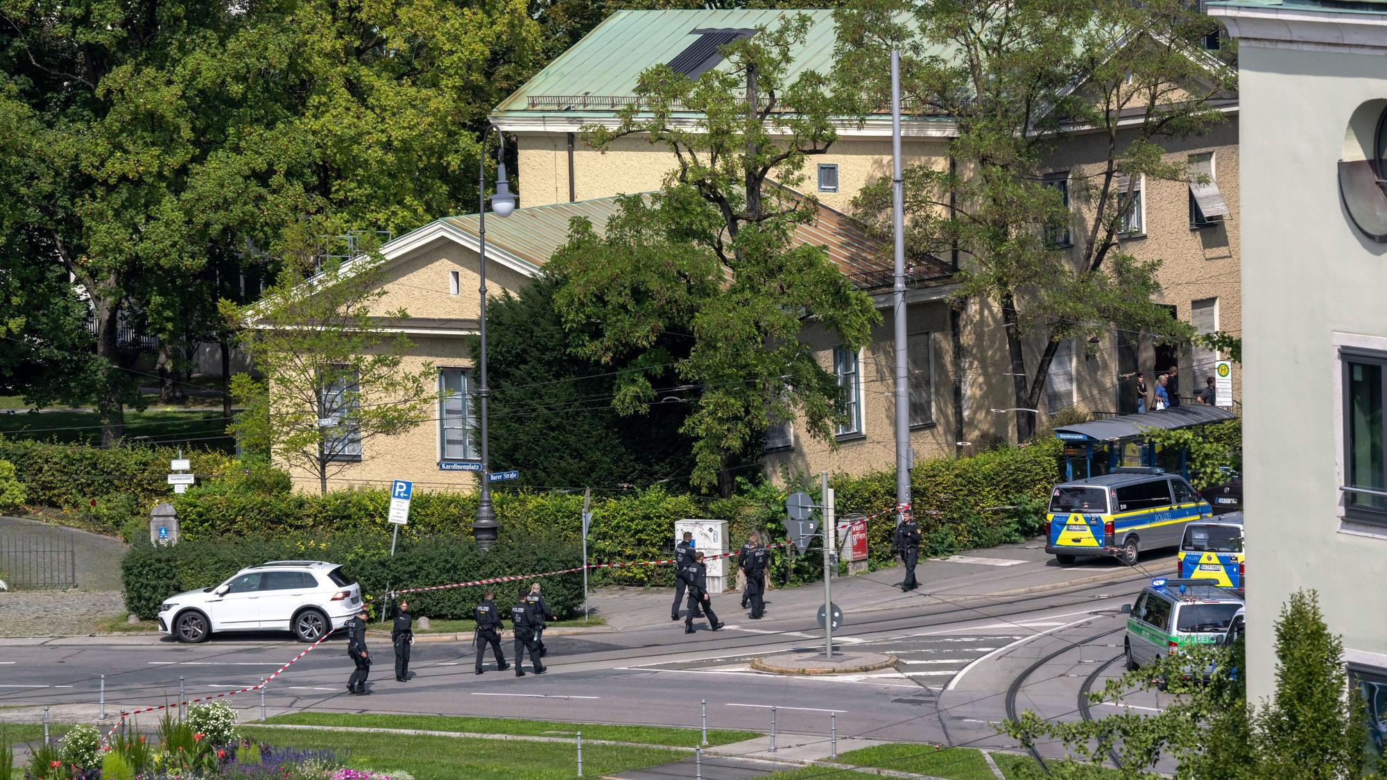 Polizisten gehen eine Straße am Karolinenplatz auf der Suche nach Spuren ab. Die Polizei hat in der Münchner Innenstadt bei einem größeren Einsatz in der Nähe des Israelischen Generalkonsulats eine verdächtige Person niedergeschossen.