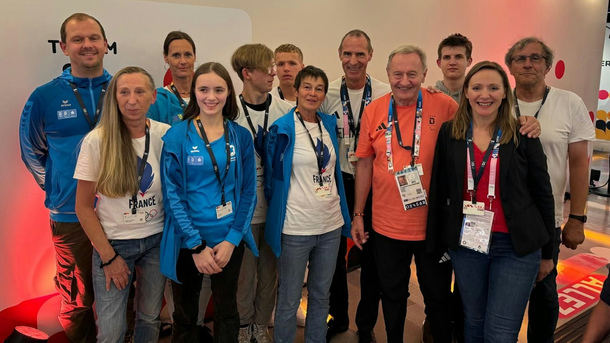 Eine Gruppe Schüler, Männer und Frauen steht im Deutschen Haus bei den Paralympics in Paris zusammen.