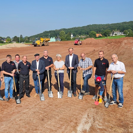 Vertreter von Stadt, Feuerwehr, der Baufirma und des Planungsbüros stehen zum Teil mit Spaten nebeneinander.