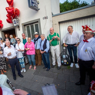 Ein Ständchen für den Jubilar: Der Chor der Roten Funken singt für Ludwig Sebus (MItte, weißes Hemd) vor der Veedelskneipe „Haus Thomas“ auf der Rochusstraße in Bickendorf. Mit Familie und Freunden feierte er seinen 99. Geburtstag.