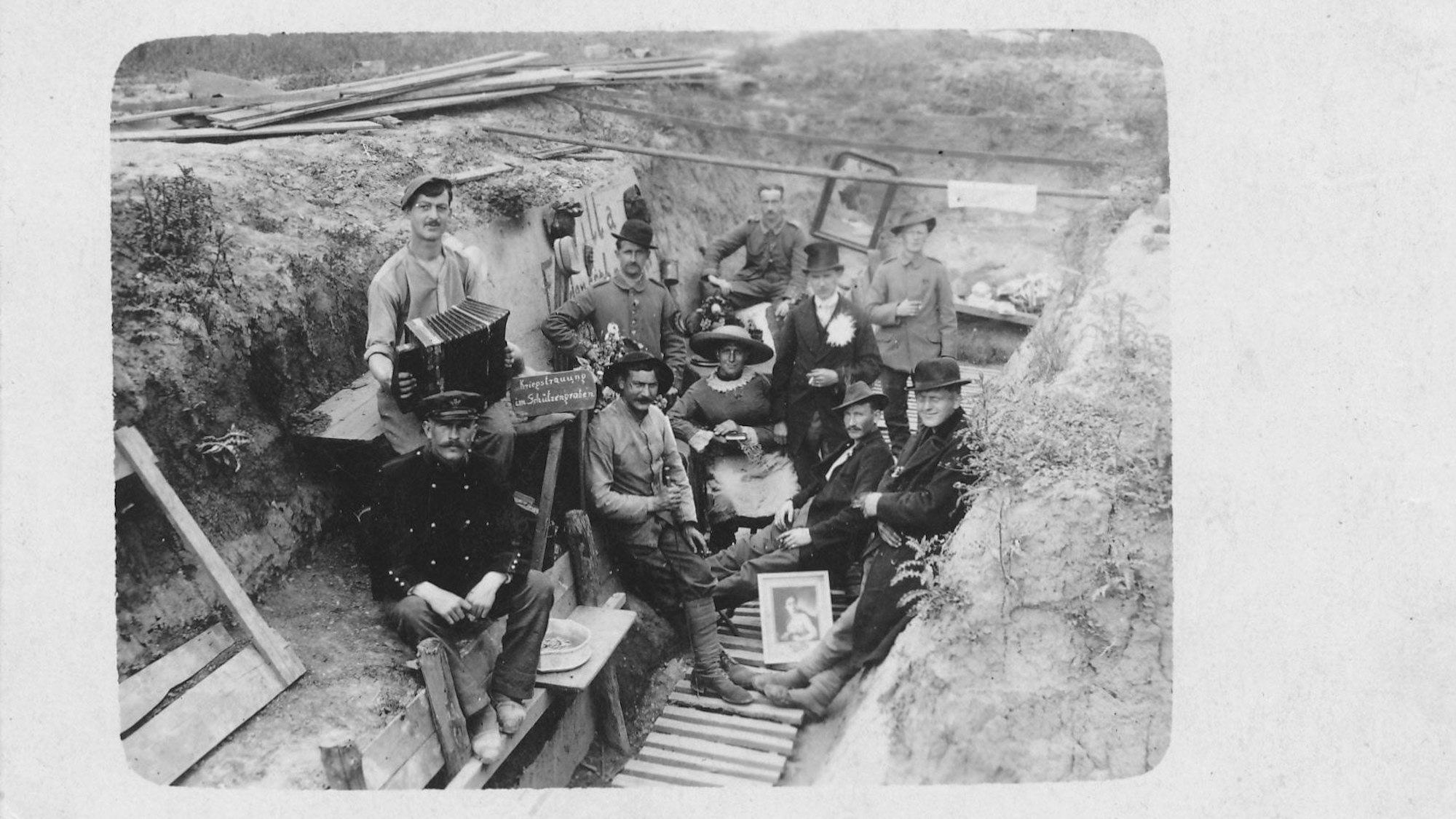 Zu sehen ist ein großes Schwarz-Weiß-Foto, das eine Hochzeit eines deutschen Soldaten 1917 an der Front in der Ukraine zeigt.
