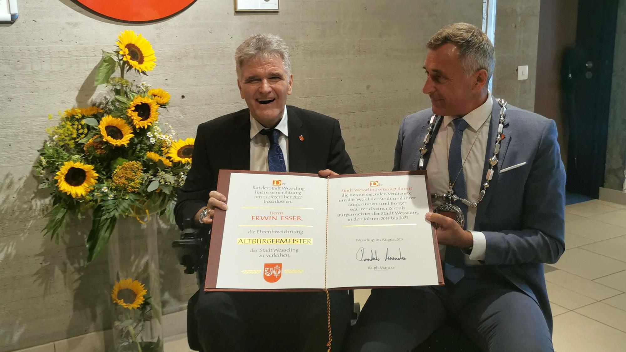 Auf dem Foto sind Ehrenbürgermeister Erwin Esser und sein Nachfolger Ralph Manzke mit der Ernennungsurkunde zu sehen.