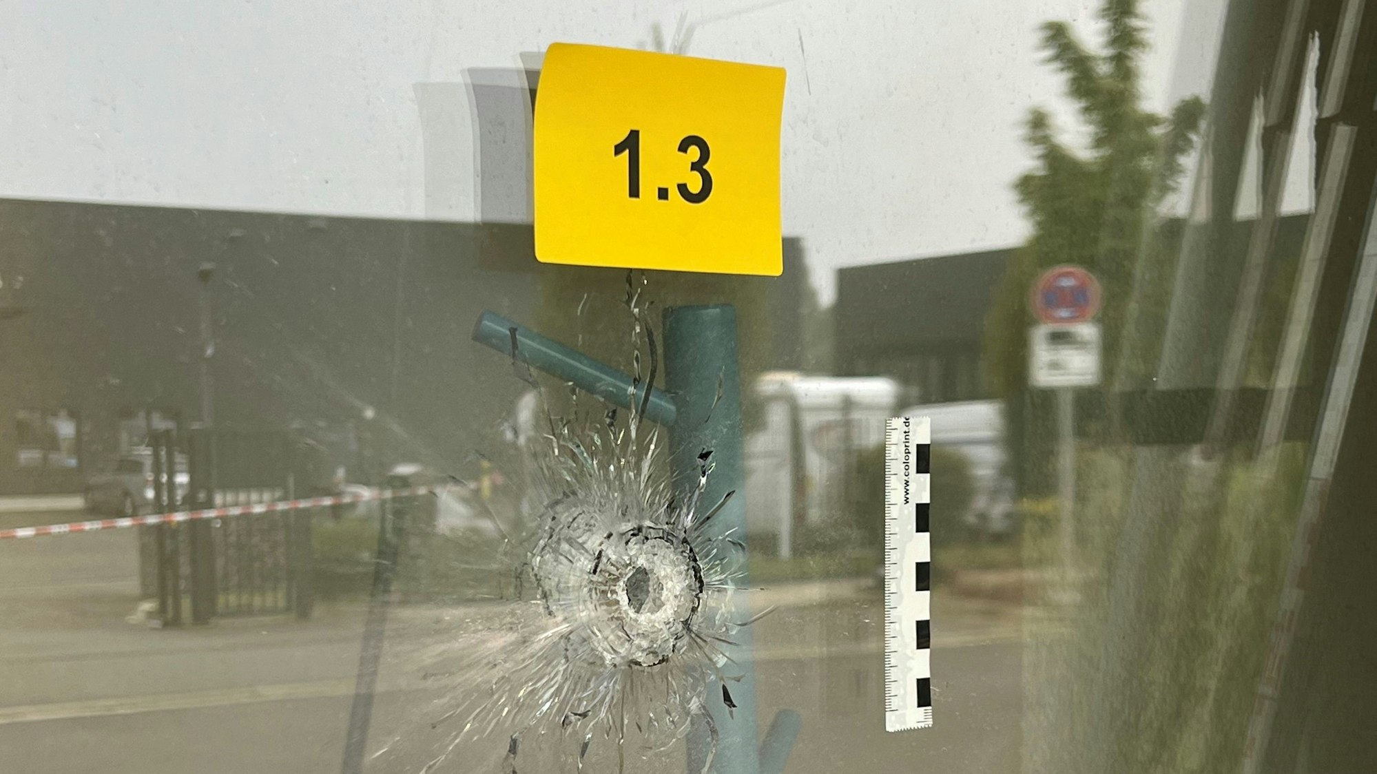 An einer Glastüre ist deutlich ein Einschussloch zu erkennen.