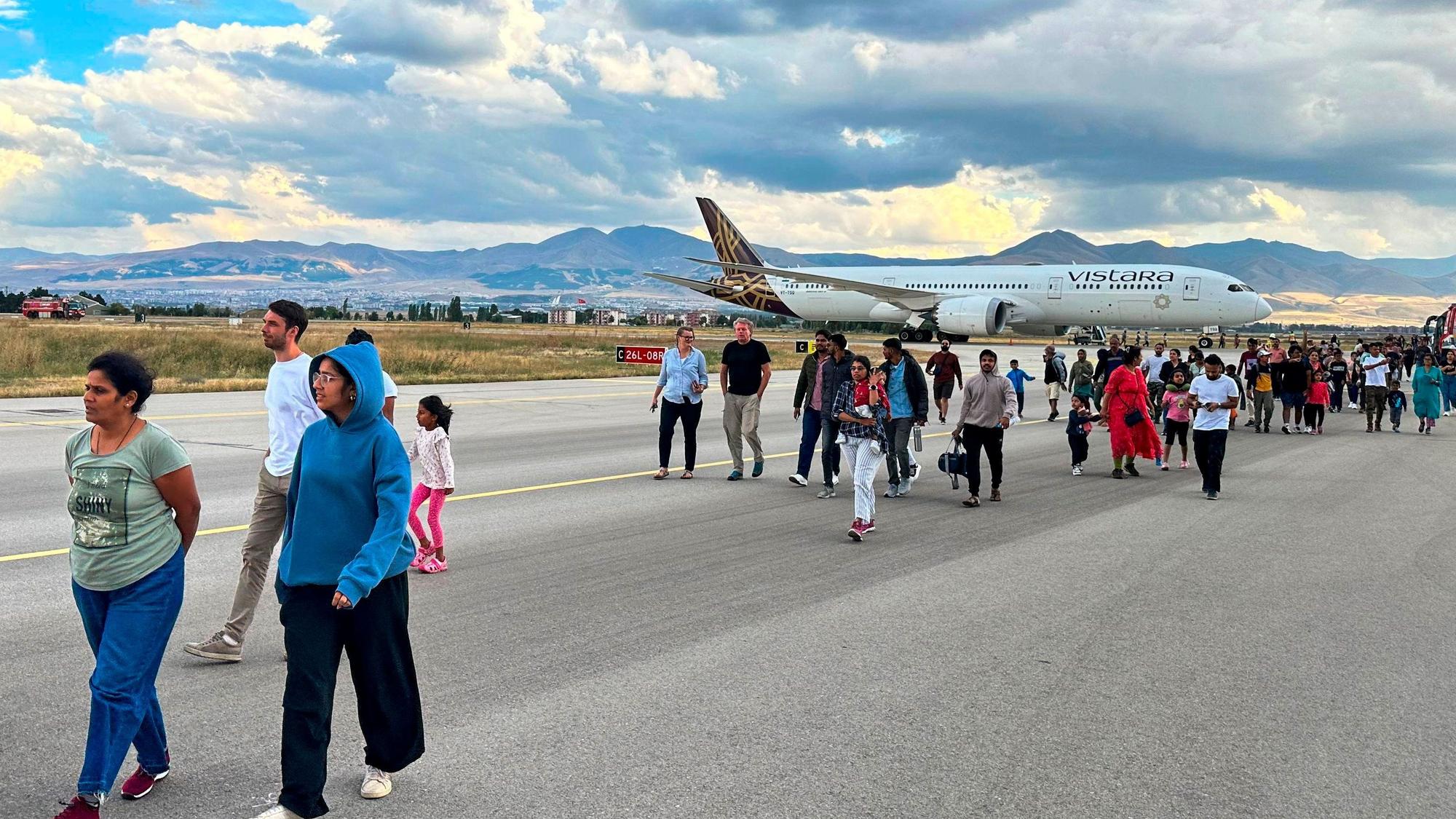 Passagiere des Vistara-Fluges VTI027 von Mumbai nach Frankfurt gehen auf dem Rollfeld entlang, als sie das Flugzeug am Flughafen Erzurum im Osten der Türkei verlassen.