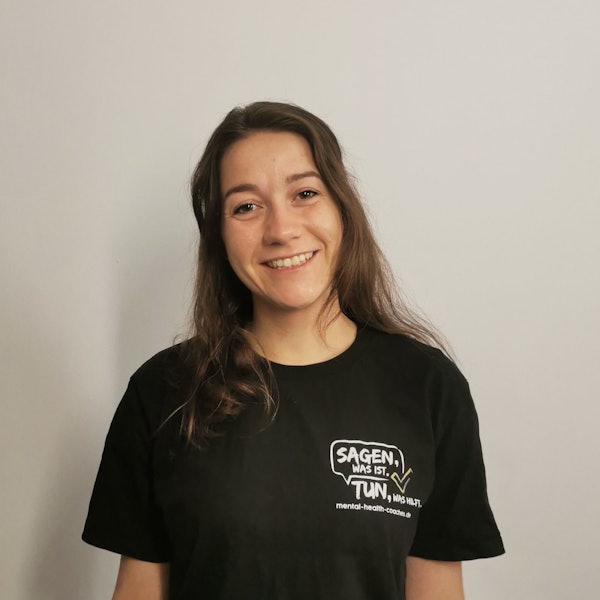 Zu sehen ist eine Frau mit dunklen langen Haaren in einem schwarzen T-Shirt.