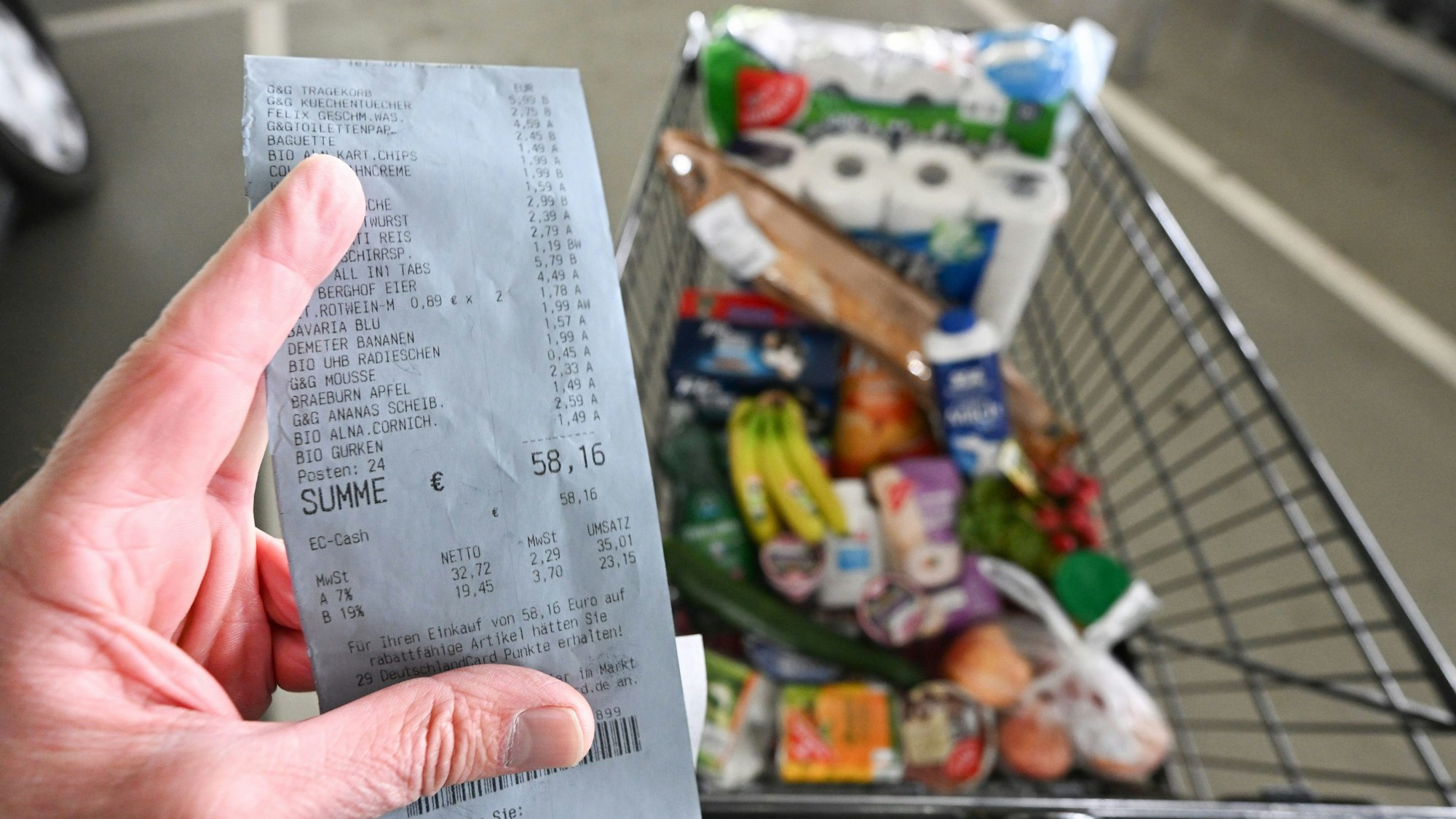 Ein Verbraucher hält nach einem Einkauf in einem Supermarkt einen Kassenzettel in der Hand.