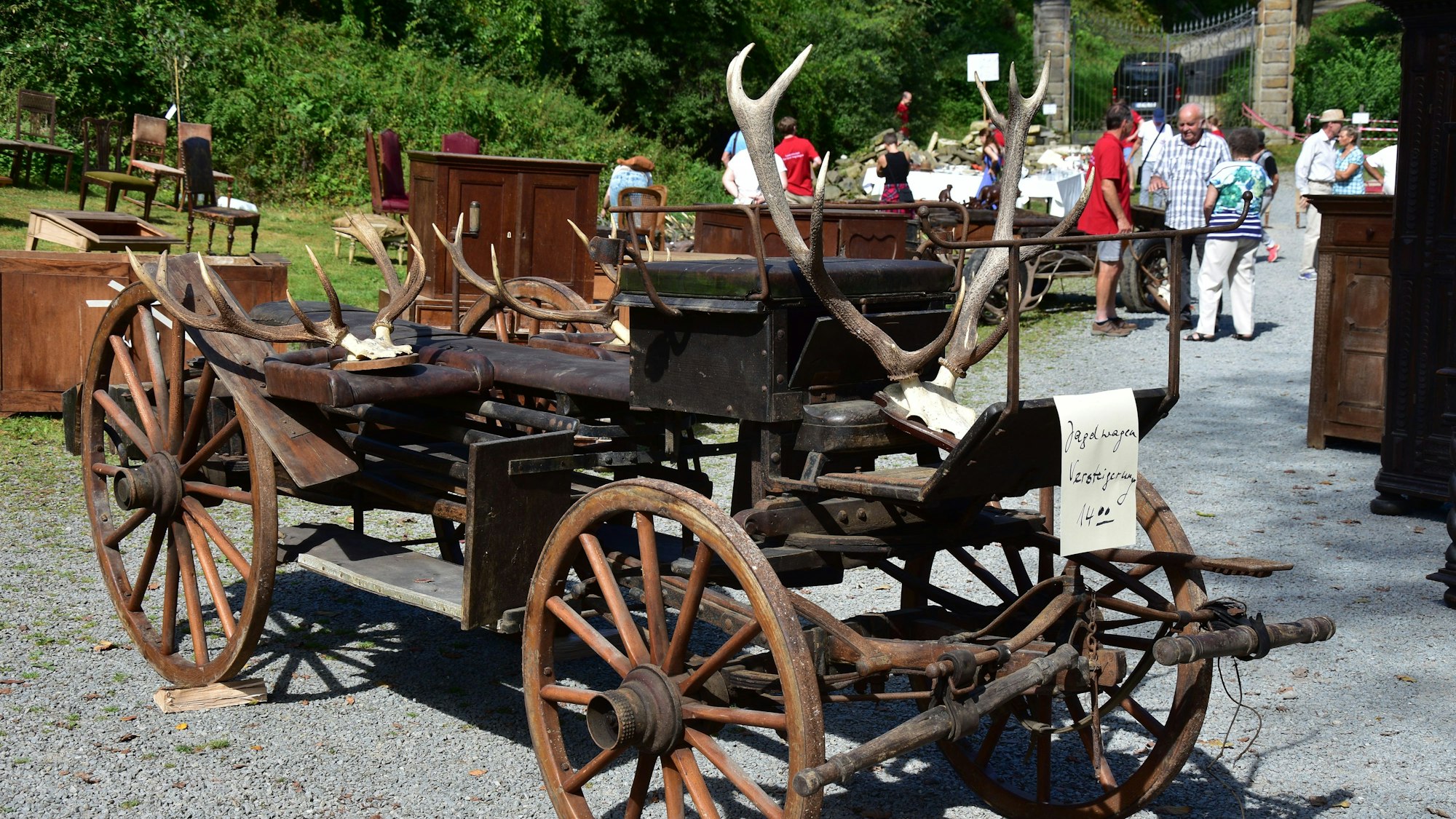 Eine offene Kutsche, darauf sind Hirschgeweihe drapiert.