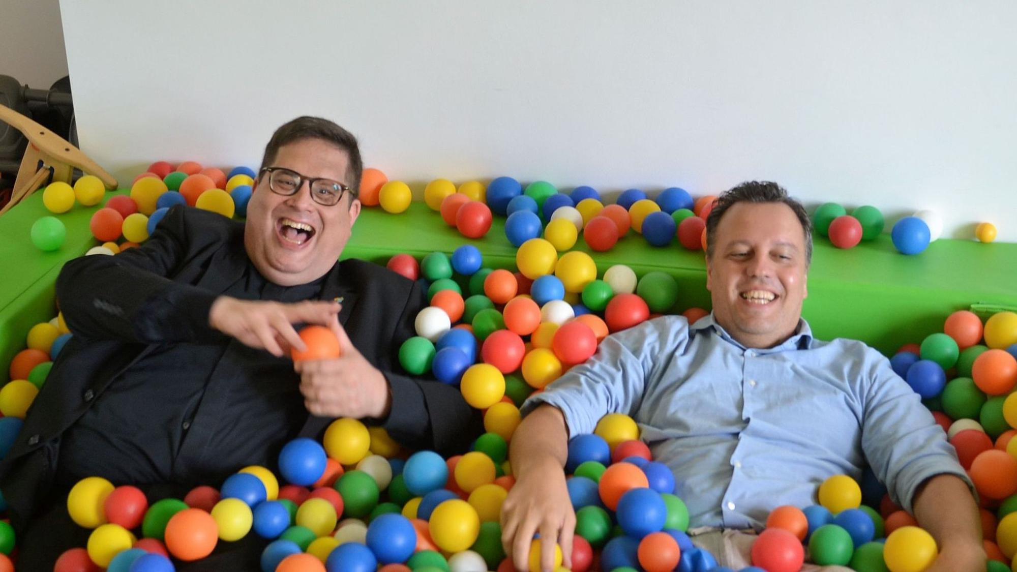 Beim Besuch einer Kita liegen Pfarrer Tobias Hopmann und Euskirchens Bürgermeister Sacha Reichelt im Bällebad.