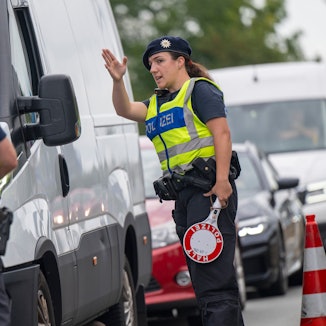 Polizisten führen Grenzkontrollen der Bundespolizei am Grenzübergang zwischen Österreich und Deutschland an der Autobahn A8 nahe Salzburg (Österreich) durch.