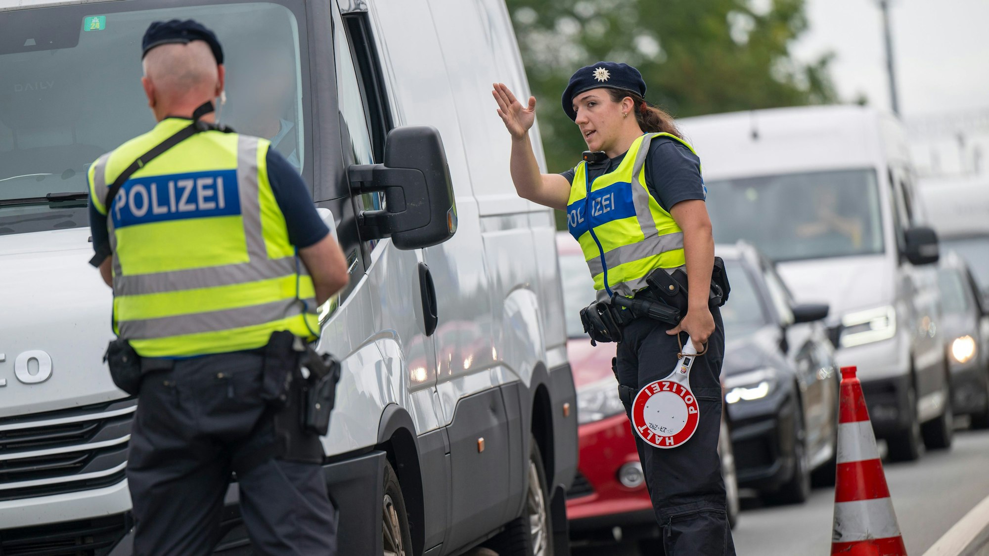 Polizisten führen Grenzkontrollen der Bundespolizei am Grenzübergang zwischen Österreich und Deutschland an der Autobahn A8 nahe Salzburg (Österreich) durch.