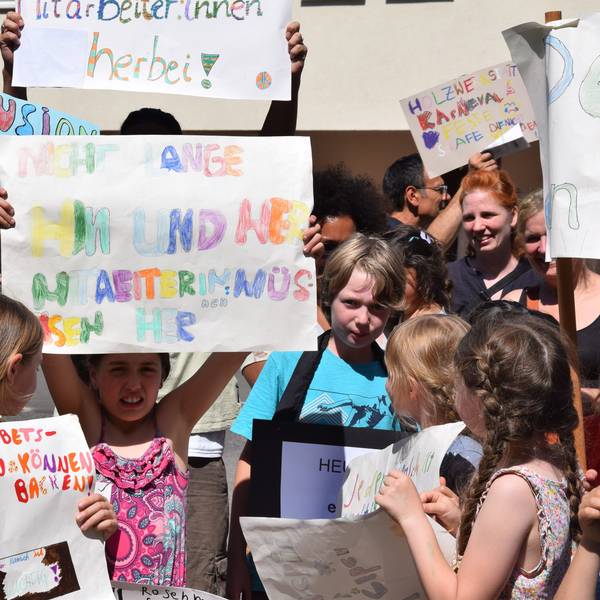 Kinder halten bunte Protestplakate hoch.