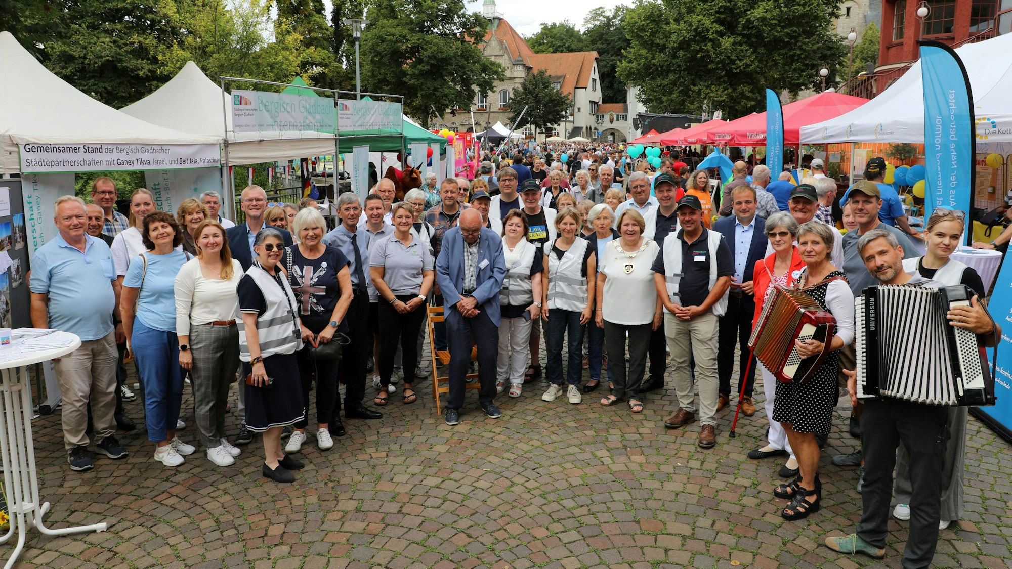 Vertreter der Städtepartnerschaftsvereine und Gäste aus den Partnerstädten stehen auf dem Bergisch Gladbacher Stadtfest.