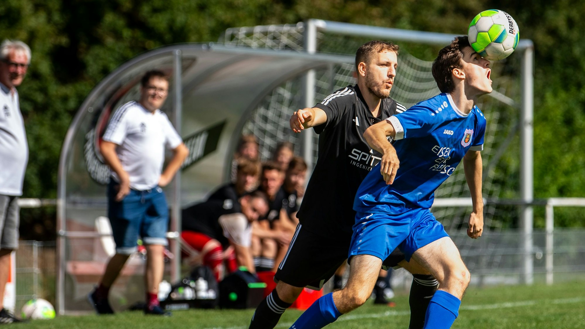 Ein Fußballer balanciert den Ball auf der Nase.