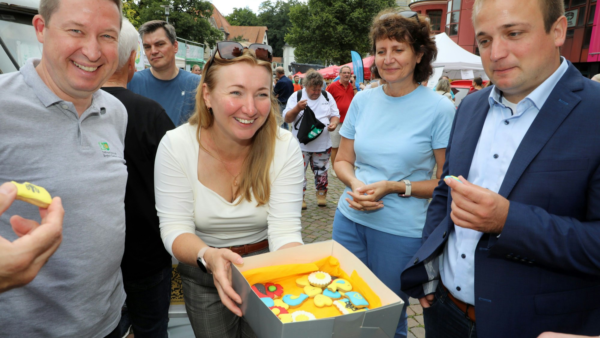 Tanja Rybakova hält ukrainische Plätzen in einer Kiste und bietet sie an.