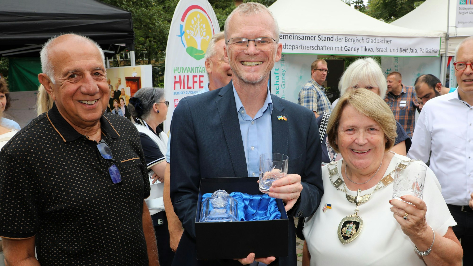 Runnymedes Bürgermeisterin Elaine Gill überreicht Bergisch Gladbachs Bürgermeister Frank Stein beim Stadtfest ein Kristallservice mit Gravur.