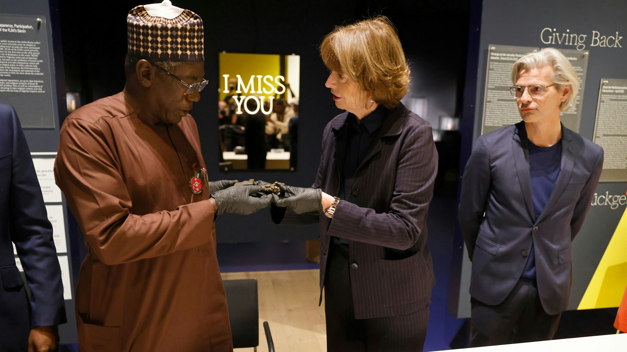 Henriette Reker (r, parteilos), Oberbürgermeisterin von Köln, übergibt Abba Isa Tijani, Generaldirektor der Nationalen Kommission für Museen und Monumente, symbolisch einen bronzenen Schlüssel aus dem Königreich Benin.