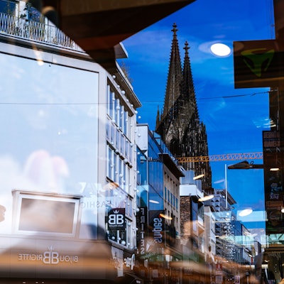 Der Kölner Dom spiegelt sich in Schaufensterscheiben.