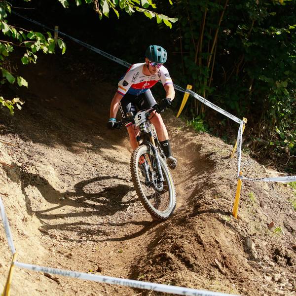 Ein E-Mountainbiker fährt bei einem Rennen über einen Waldkurs.