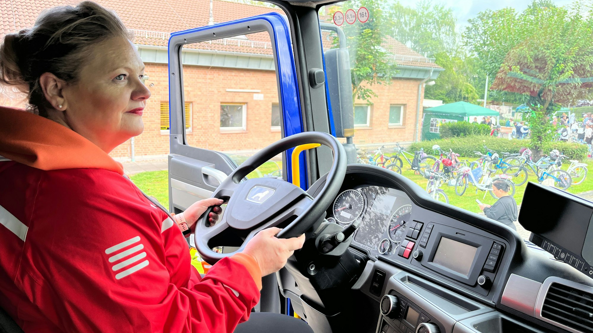 Eine Frau sitzt am Lenker eines Lastwagens.
