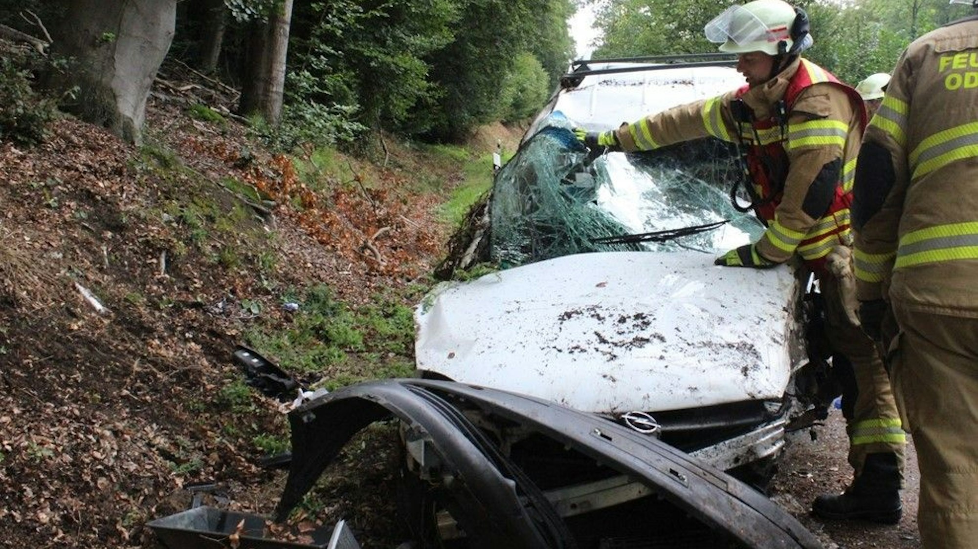Feuerwehrleute bergen Einzelteile eines Unfalautos.