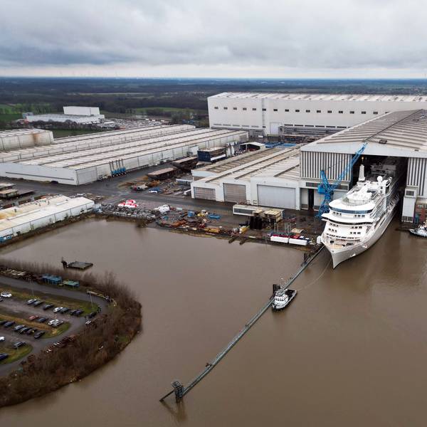 Ein Bild des Geländes der Meyer Werft von oben. Ein Kreuzfahrtschiff verlässt das überdachte Baudock der Meyer Werft.